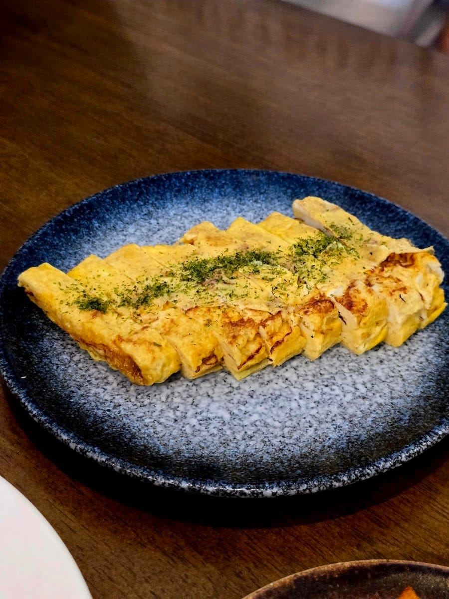 Sliced Japanese rolled omelette on a blue speckled plate